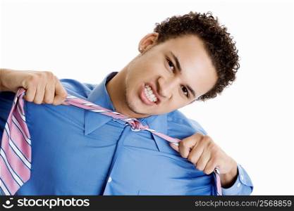 Portrait of a young man pulling his tie
