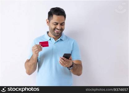Portrait of a young man shopping online through Smartphone using credit card 