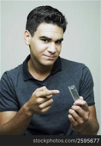 Portrait of a young man showing a condom