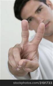 Portrait of a young man showing a peace sign