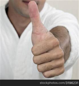 Portrait of a young man showing a thumbs up sign