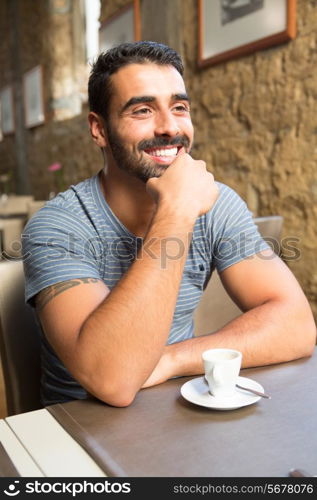 Portrait of a young man sitting at cafe table