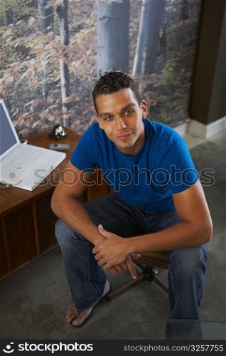 Portrait of a young man sitting near a laptop