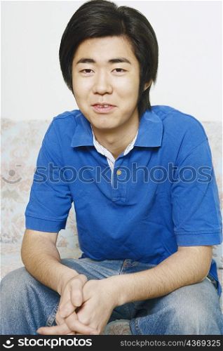 Portrait of a young man sitting on a couch