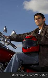Portrait of a young man sitting on a motorcycle