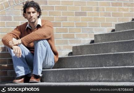 Portrait of a young man sitting on a staircase