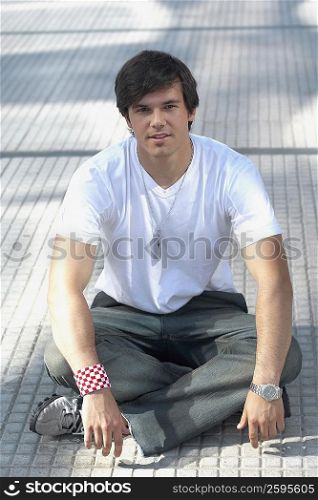 Portrait of a young man sitting on the floor