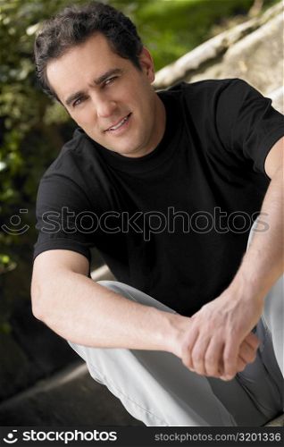 Portrait of a young man sitting with his hands clasped