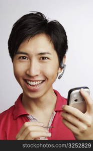 Portrait of a young man smiling and holding a personal data assistant