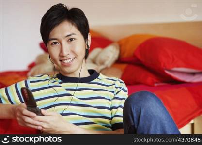 Portrait of a young man smiling and listening to music