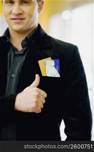 Portrait of a young man smiling and making a thumbs up sign