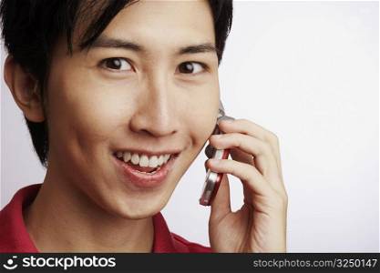 Portrait of a young man smiling and talking on a mobile phone