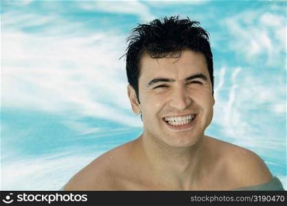 Portrait of a young man smiling in a swimming pool