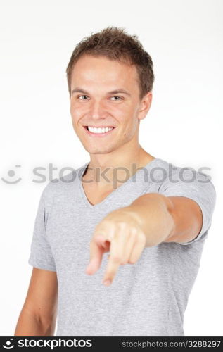 Portrait of a young man smiling, pointing at you. Studio shot. Isolated on white.