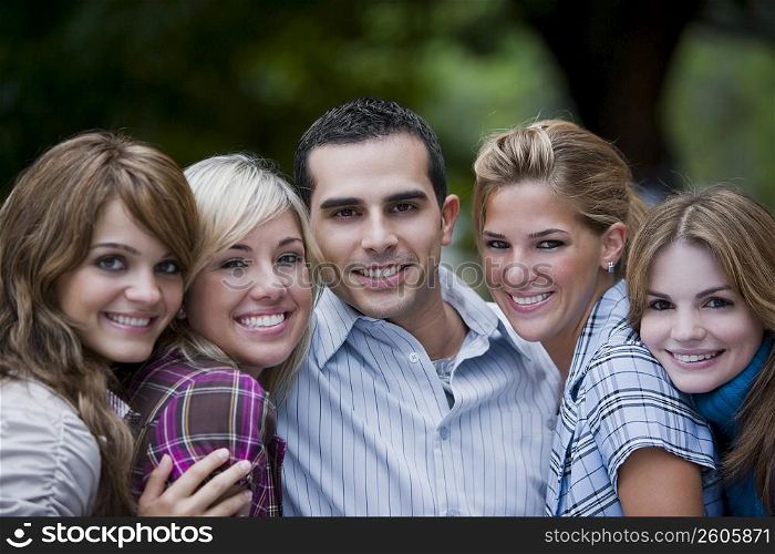 Portrait of a young man smiling with four young women