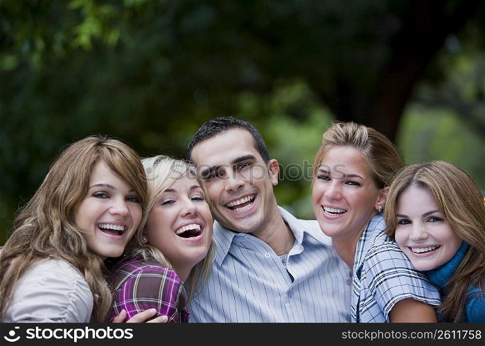 Portrait of a young man smiling with four young women