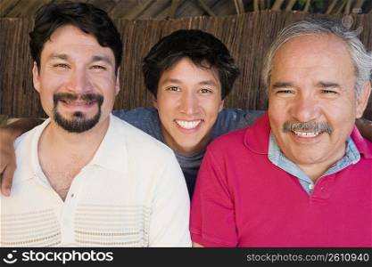 Portrait of a young man smiling with his father and grandfather
