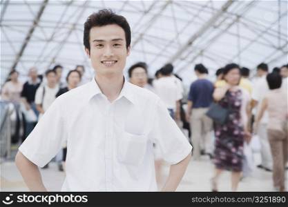 Portrait of a young man standing in a corridor and smiling