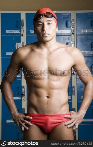 Portrait of a young man standing in a locker room