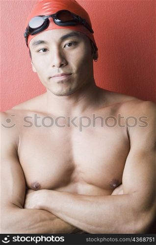 Portrait of a young man standing with his arms crossed