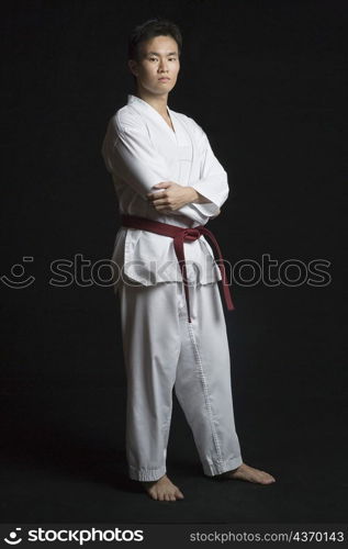 Portrait of a young man standing with his arms crossed