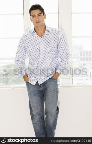 Portrait of a young man standing with his hands in his pockets