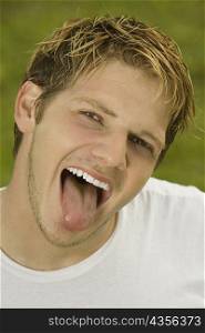 Portrait of a young man sticking out his tongue