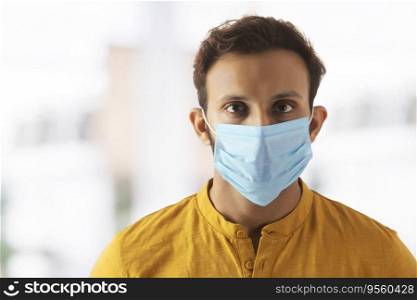Portrait of a young man taking precautions by wearing a mask