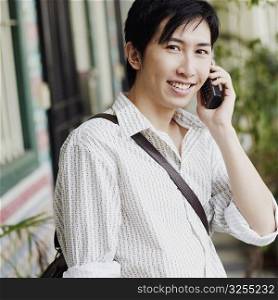 Portrait of a young man talking on a cordless phone