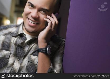 Portrait of a young man talking on a mobile phone and smiling