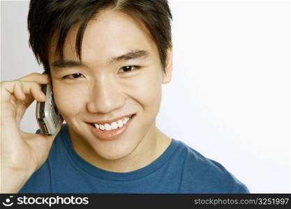 Portrait of a young man talking on a mobile phone and smiling