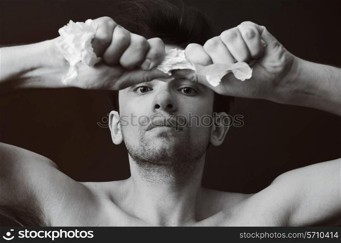 Portrait of a young man tearing paper