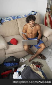 Portrait of a young man using a laptop and smiling