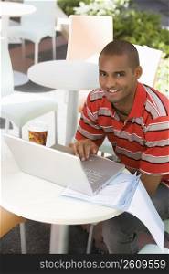 Portrait of a young man using a laptop in a cafe