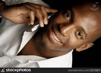 Portrait of a young man using a mobile phone and smiling