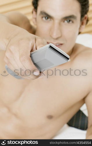 Portrait of a young man using a remote control