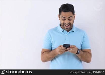 Portrait of a young man using Smartphone against white background