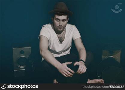Portrait of a young man wearing a hat with a music equipment