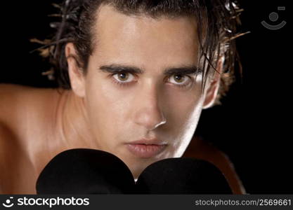 Portrait of a young man wearing boxing gloves