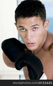 Portrait of a young man wearing boxing gloves