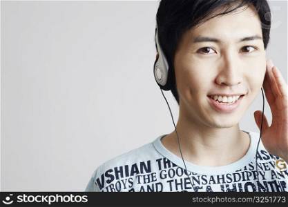 Portrait of a young man wearing headphones and listening to music