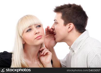 Portrait of a young man whispering a secret to a cute woman against white