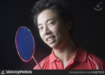 Portrait of a young man with a badminton racket