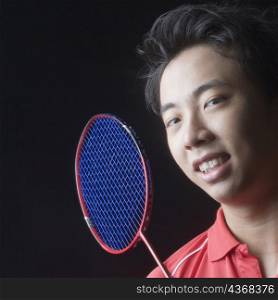 Portrait of a young man with a badminton racket