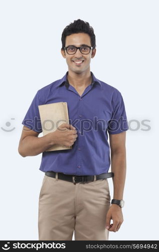 Portrait of a young man with a book smiling