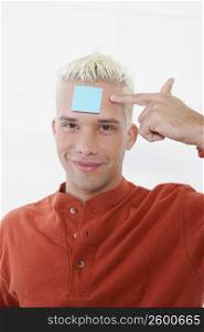 Portrait of a young man with an adhesive note on his forehead