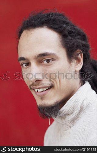 Portrait of a young man with dreadlocks smiling