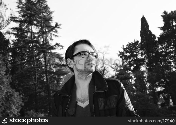 Portrait of a young man with glasses outdoors