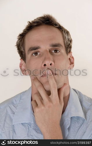 Portrait of a young man with his finger on his lips