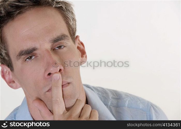 Portrait of a young man with his finger on his lips